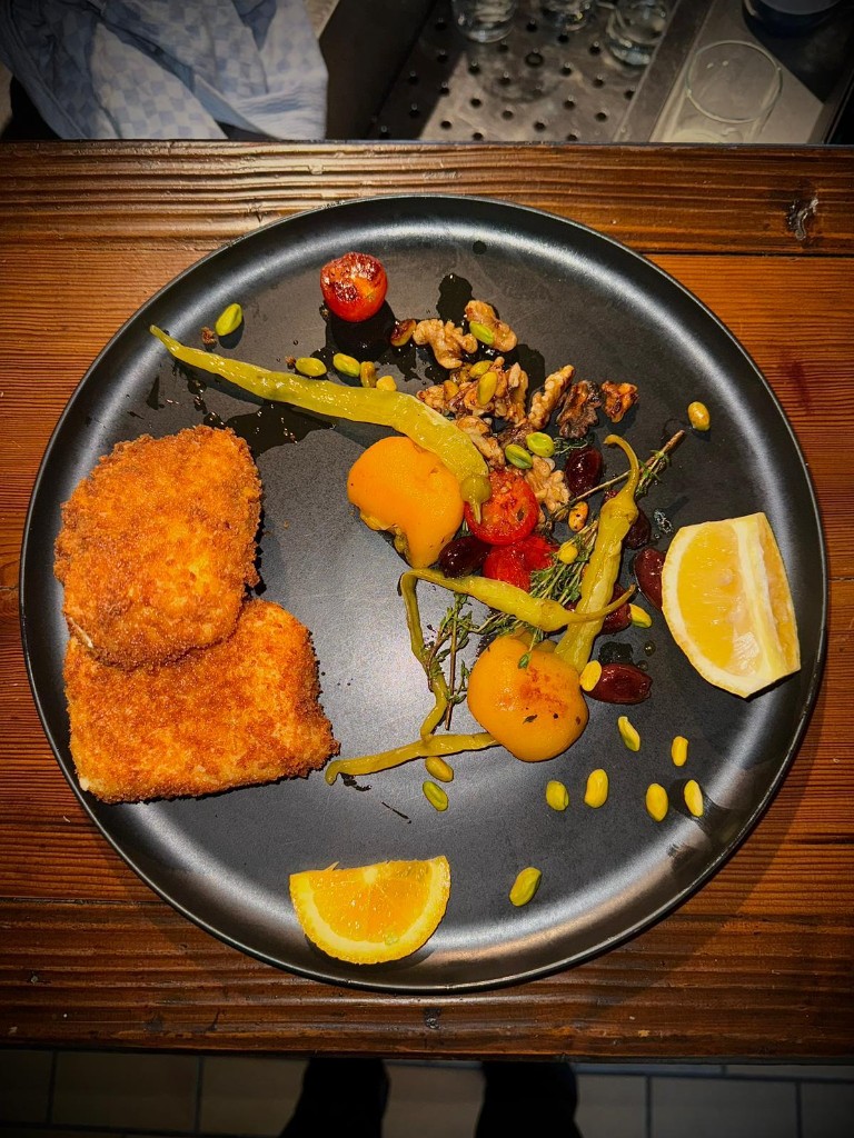 Paniertes Gericht mit mediterranen Beilagen