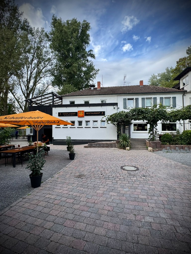 Restaurant Seeflamme bei Tag – Terrasse mit Sonnenschirmen vor dem Weißen Häus'l